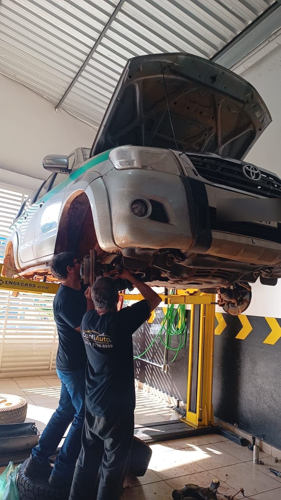 Mecânicos da Confiauto trabalhando na suspensão de um veículo